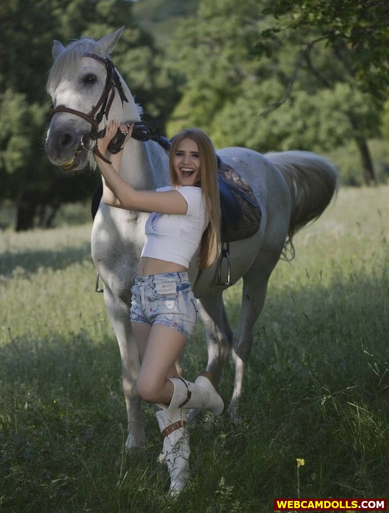 Blonde Horse Rider in Blue Denim Shorts and White Boots on Webcamdolls